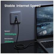 UGREEN Cat6 cable connecting a laptop to an Ethernet wall port with 1000Mbps and 250MHz specifications